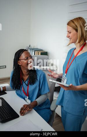 Two nurses discussing patient information using a digital tablet Stock Photo