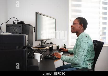 African american woman working from home using computer Stock Photo