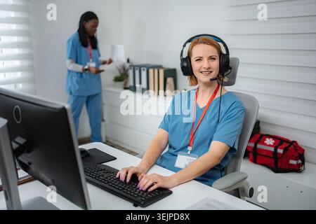Medical dispatcher wearing headset working in emergency call center Stock Photo