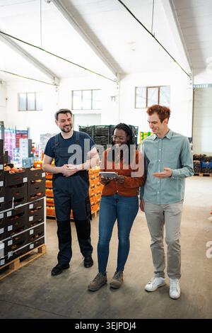 Warehouse workers collaborating on logistics using tablet technology Stock Photo