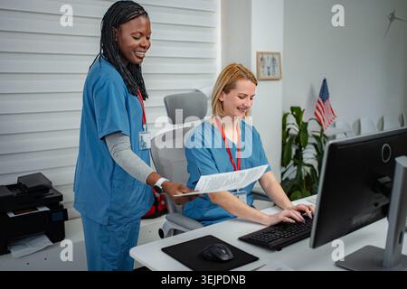 Medical professionals collaborating on documents at clinic front desk Stock Photo