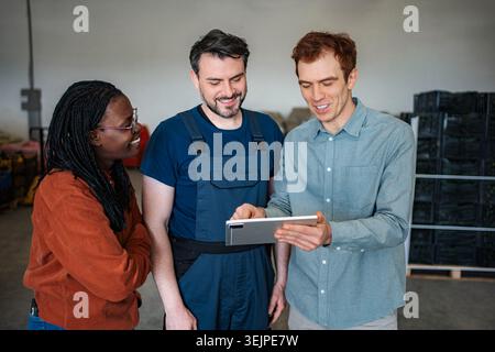 Warehouse workers collaborating on digital tablet for logistics management Stock Photo