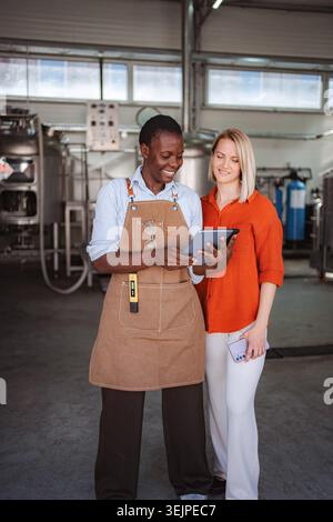 Diverse brewery owners using tablet for quality control inspection Stock Photo