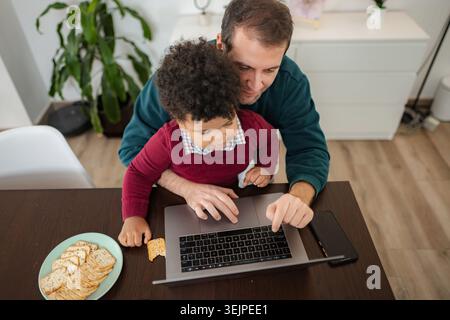 Father and son using laptop for online education Stock Photo