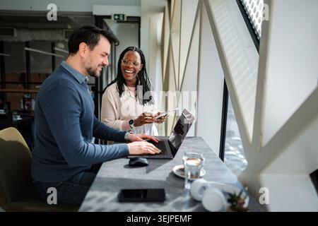 Coworkers collaborating remotely laughing while discussing business ideas Stock Photo