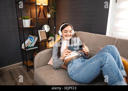 Relaxed young woman using mobile phone Stock Photo