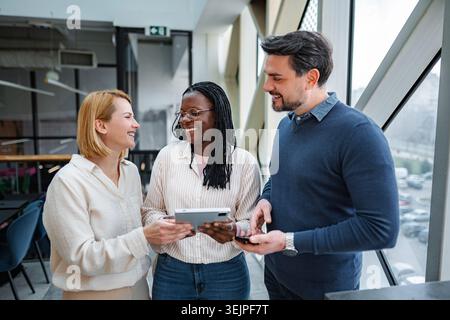 Diverse business team collaborating using digital tablet in office Stock Photo