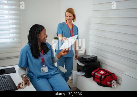 Healthcare professionals collaborating on documents in clinic office Stock Photo