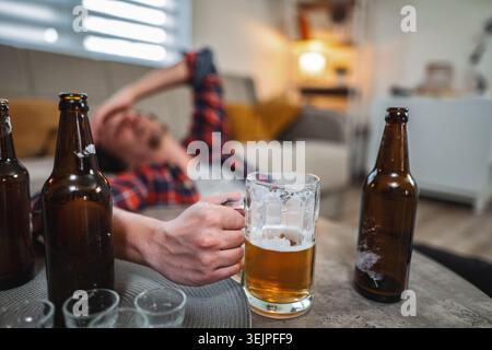 Young man drinking too much beer at home Stock Photo