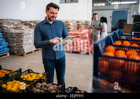 Man using tablet checking inventory in food warehouse Stock Photo