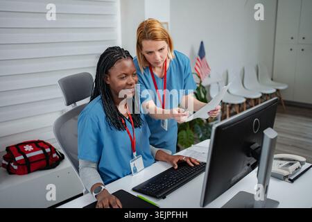 Healthcare professionals collaborating on computer in medical office Stock Photo