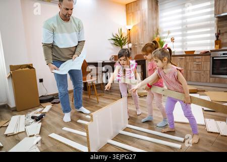 Creative family time while assembling furniture in a cozy home Stock Photo