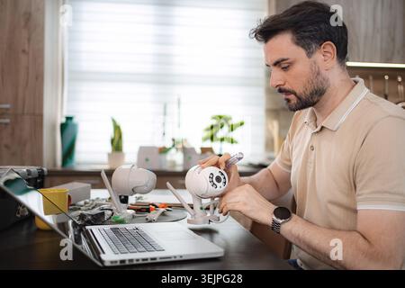 Technician installing a surveillance camera at home using a laptop Stock Photo
