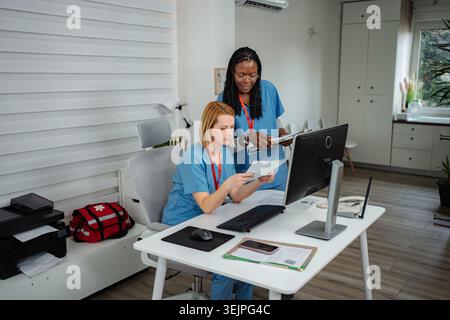Medical professionals collaborating on patient data in clinic Stock Photo