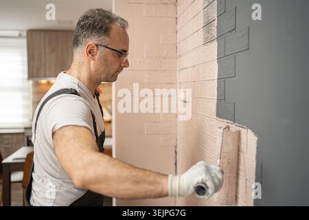 Man Working on Brick Wall Stock Photo