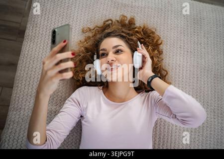 Young woman enjoying music and video calling with smartphone Stock Photo