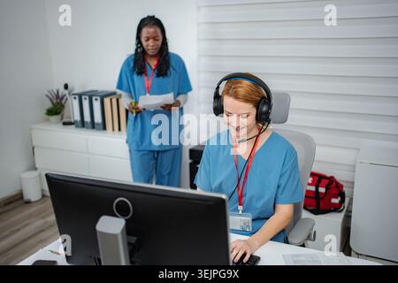 Medical professionals providing remote healthcare assistance in an office Stock Photo