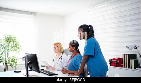 Diverse medical team working together in doctor's office Stock Photo