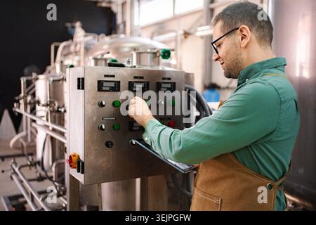 Man working on control panel in modern brewery Stock Photo