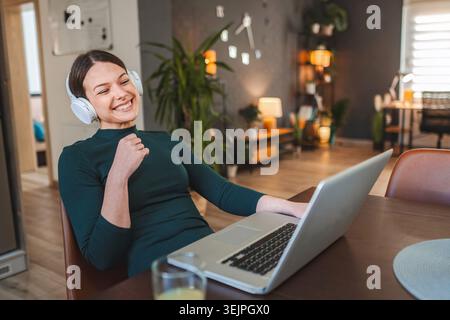 Young Woman Celebrating Success While Working From Home Stock Photo