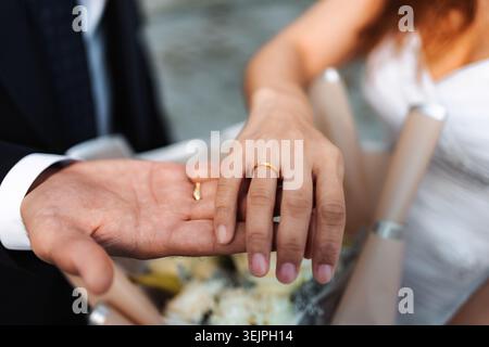 Diverse couple exchanging wedding rings on marriage day Stock Photo