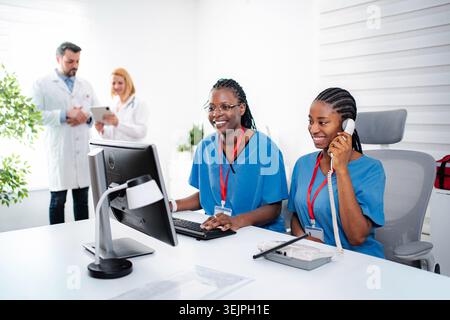 Healthcare professionals collaborating and communicating in a busy modern clinic Stock Photo