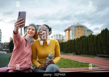 Diverse friends taking selfie celebrating friendship outdoors Stock Photo