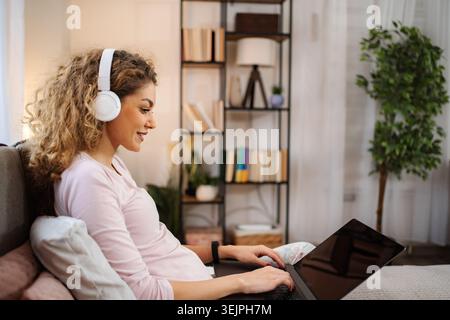 Woman enjoying remote work watching something on laptop Stock Photo