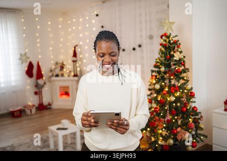 Happy woman using digital tablet during Christmas holidays Stock Photo