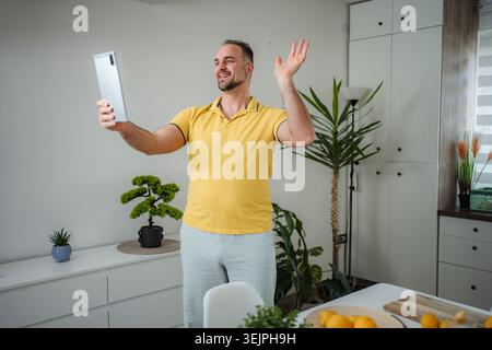 Man having video call with tablet at home Stock Photo
