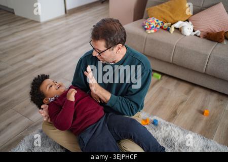 Father playing and laughing with son at home Stock Photo