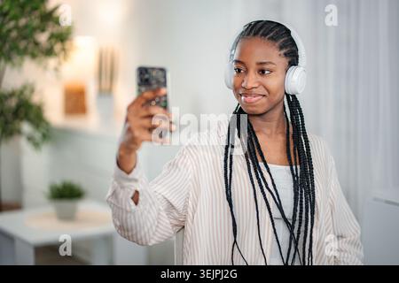 Young woman wearing headphones using smartphone for content creation Stock Photo
