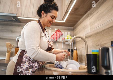Woman washing dishes in the kitchen Stock Photo