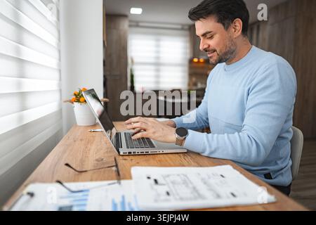 Man Sitting at Table Using Laptop Computer Stock Photo