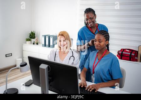 Healthcare professionals collaborating on computer in medical office Stock Photo