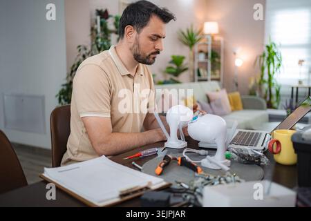 Technician installing surveillance camera system at home using laptop Stock Photo