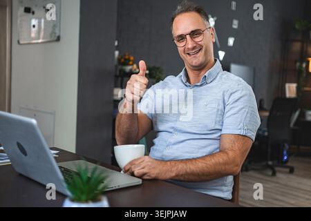 Middle aged Caucasian man working on laptop at home Stock Photo