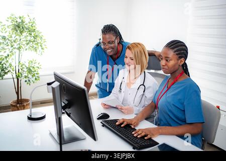 Healthcare team collaborating on computer in clinic office Stock Photo