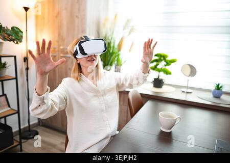 Woman exploring virtual reality in a cozy indoor setting Stock Photo