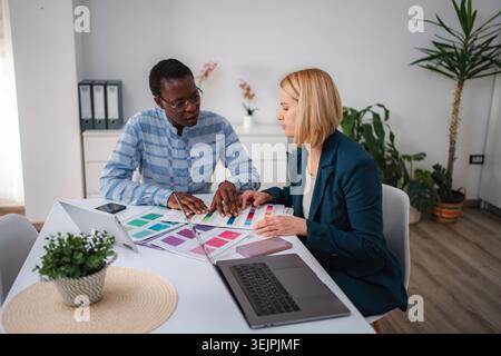 Diverse colleagues discussing color palettes for creative design project Stock Photo