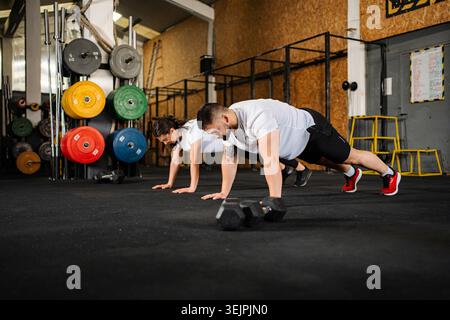Fit couple doing plank exercise in gym for strength training Stock Photo