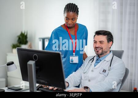 Medical team collaborating on computer in healthcare office Stock Photo