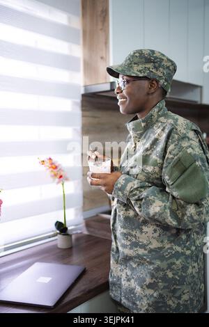 Smiling african american soldier enjoying breakfast in kitchen Stock Photo