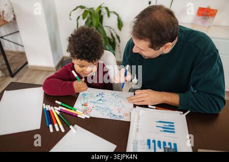 Father and son bonding while drawing at home Stock Photo