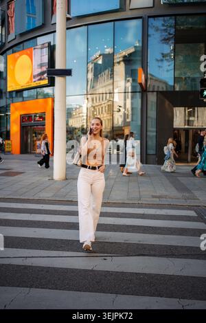 Young woman confidently walking, talking on phone in Vienna Stock Photo
