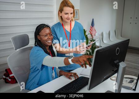 Diverse nurses collaborating accessing patient data using digital technology Stock Photo