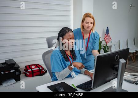 Medical professionals collaborating on computer in clinic office Stock Photo