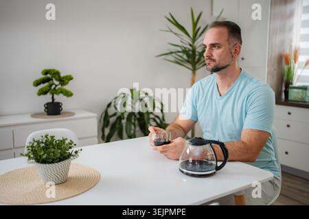 Man drinking coffee at home contemplating his morning Stock Photo