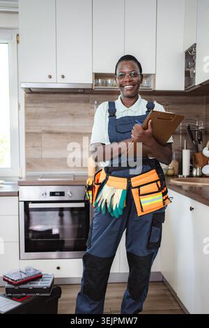 Smiling african american female technician working in kitchen Stock Photo