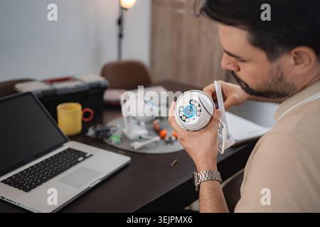 Technician installing surveillance camera at home using laptop Stock Photo